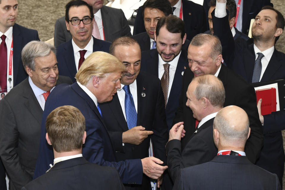FILE - In this Saturday, June 29, 2019 file photo, U.S President Donald Trump, center left, talks with Russian President Vladimir Putin, center right, as Turkey's President Recep Tayyip Erdogan, second right, and United Nations Secretary-General Antonio Guterres, second left, look on, on the sidelines of the G-20 summit in Osaka, Japan. The Thursday, March 26, 2020 virtual meeting of the Group of 20 nations, with more than a dozen heads of state participating, was less a global summit and more of a high-powered conference call. It lasted about 90 minutes — the same as a standard soccer match — instead of the usual, more languid two days. (Presidential Press Service via AP, Pool)