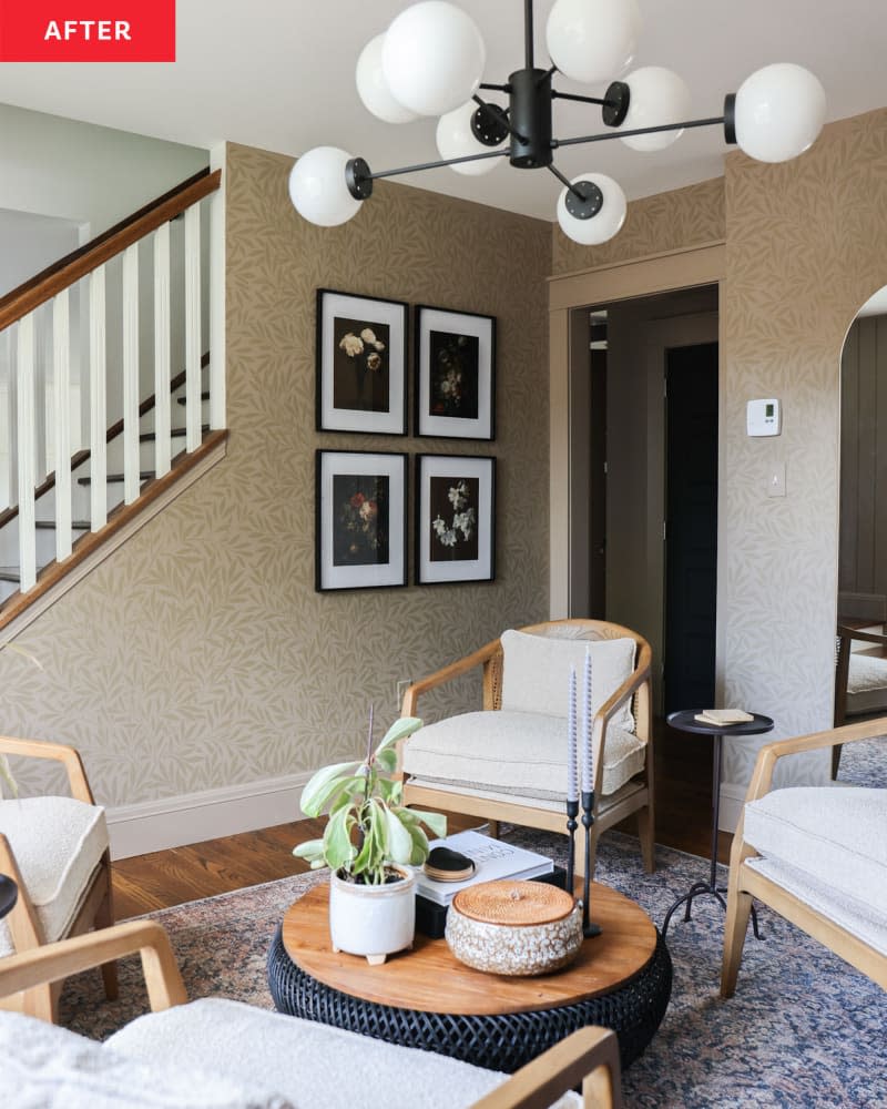 A living room with four white chairs and a beige floral wallpaper.