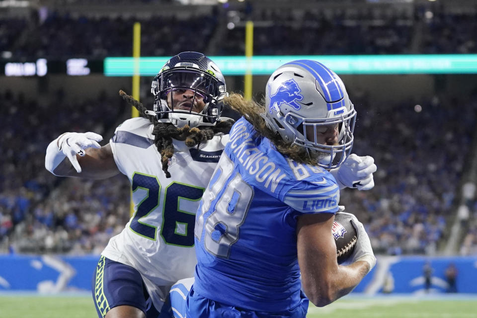 Detroit Lions tight end T.J. Hockenson (88), defended by Seattle Seahawks safety Ryan Neal (26), catches a 4-yard pass for a touchdown during the second half of an NFL football game, Sunday, Oct. 2, 2022, in Detroit. (AP Photo/Paul Sancya)