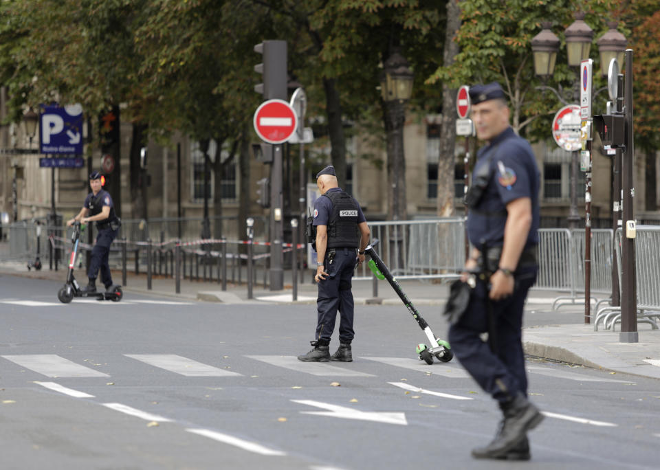 Police officers remove electric scooters from the area around Notre Dame cathedral in Paris, Monday, Aug. 12, 2019. Authorities started clearing the area around Notre Dame ahead of decontamination and cleanup work which will resume on Aug. 19 after new equipment and stricter safety procedures ensure workers are not exposed to unsafe levels of lead. (AP Photo/Lewis Joly)