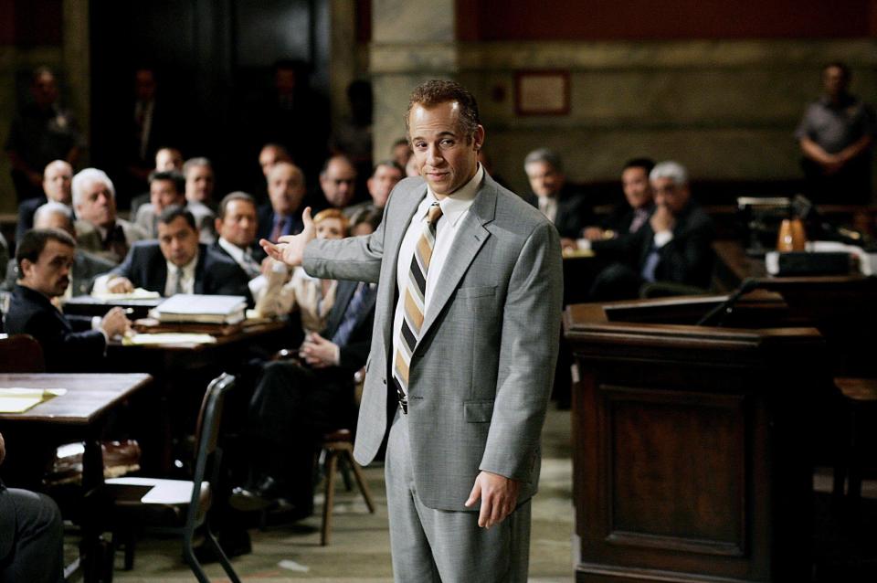 A gangster in a suit attempts to defend himself in court