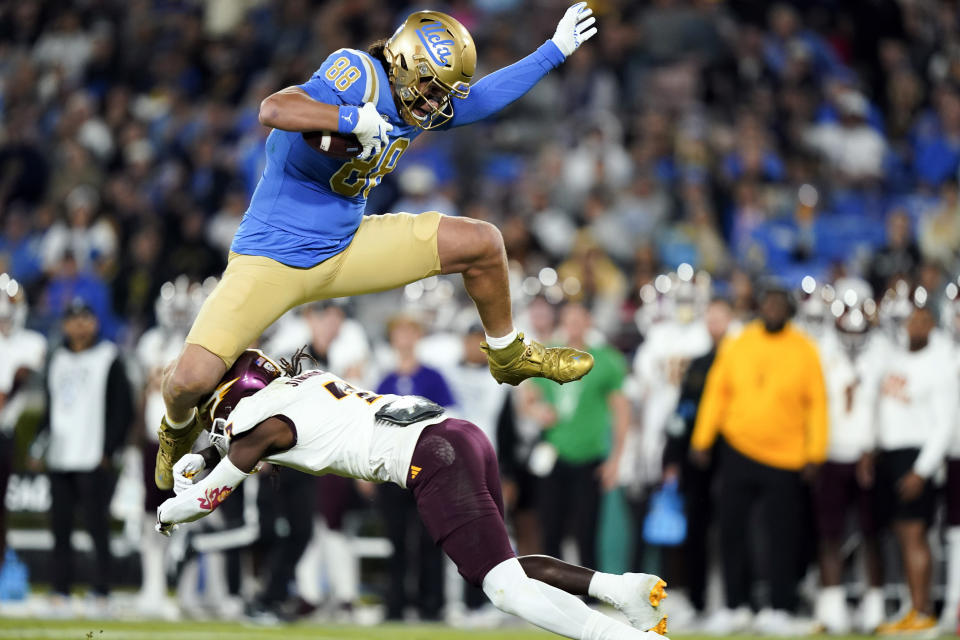 UCLA tight end Moliki Matavao, top, hurdles Arizona State defensive back Shamari Simmons during the first half of an NCAA college football game, Saturday, Nov. 11, 2023, in Pasadena, Calif. (AP Photo/Ryan Sun)