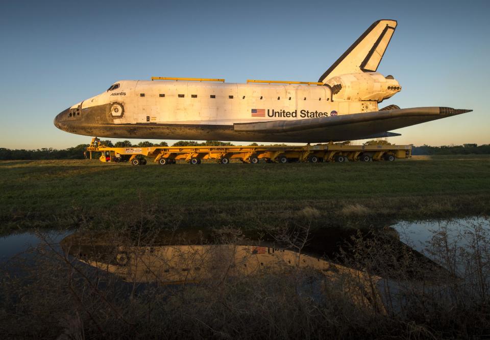 Space shuttle Atlantis rolls down Kennedy Parkway on its way to its new home at the Kennedy Space Center Visitor Complex, Friday, Nov. 2, 2012, in Cape Canaveral, Fla. The spacecraft traveled 125,935,769 miles during 33 spaceflights, including 12 missions to the International Space Station. Its final flight, STS-135, closed out the Space Shuttle Program era with a landing on July 21, 2011. (AP Photo/NASA, Bill Ingalls)