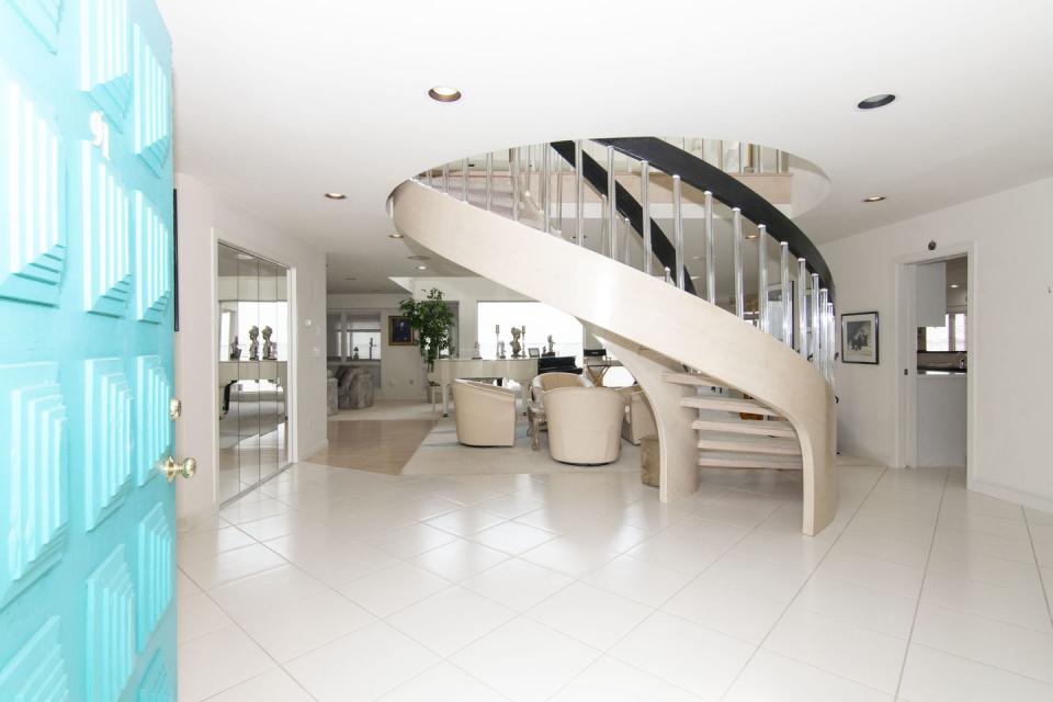 2) The Foyer Features a Dramatic Curved Staircase
