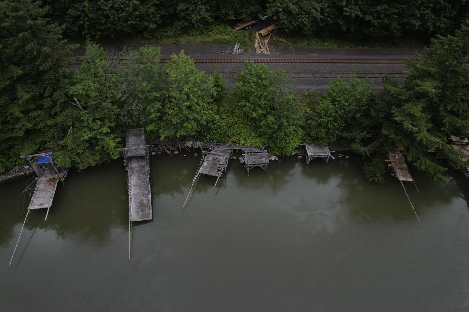 Scaffolds used by Indigenous people while fishing line the banks of the Columbia River in Fort Rains, Wash., on Saturday, June 18, 2022. The waterway, which Natives call Nch’i-Wána, or “the great river,” has sustained Indigenous people in the region for millennia. (AP Photo/Jessie Wardarski)
