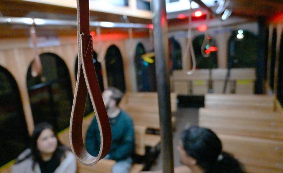 Traditional leather hand straps hang in Fresno’s new FresnoHOP, a free trolley service linking Fresno City College, Fresno State’s Campus Pointe, the Cultural Arts District, the Tower District and the Brewery District together on Friday night, Nov. 10, 2023 in Fresno.