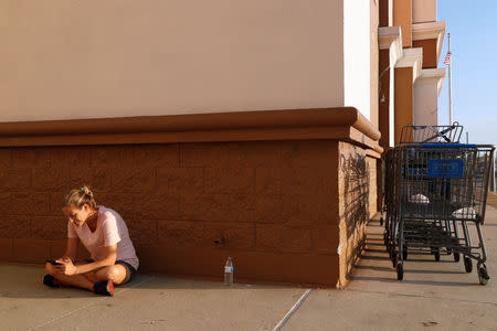 Amanda Jones, 34, of Lynn Haven, takes advantage of free wireless internet at a Wal-Mart to check her phone, following cellular network disruptions in the aftermath of Hurricane Michael in Lynn Haven, Florida, U.S., October 14, 2018. REUTERS/Terray Sylvester