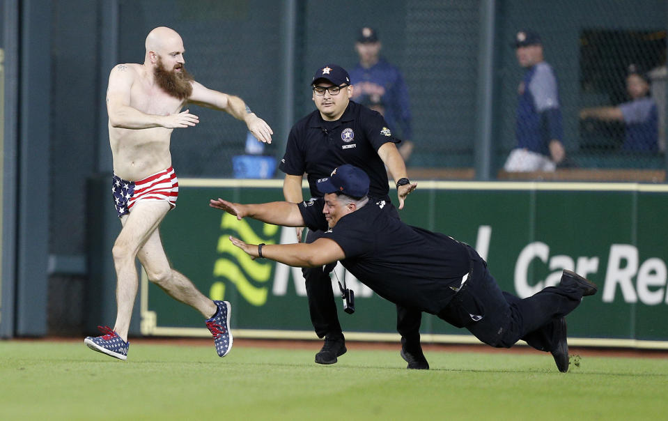 Security attempts to apprehend a fan that ran into the field at the end of the game between the Texas Rangers and the Houston Astros at Minute Maid Park on July 27, 2018 in Houston, Texas. (Photo by Bob Levey/Getty Images)