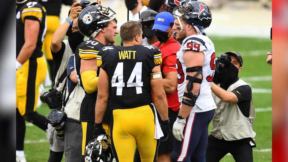 T.J., Derek, and J.J. Watt converse on the football field during a game between the Pittsburgh Steelers and the Houston Texans.