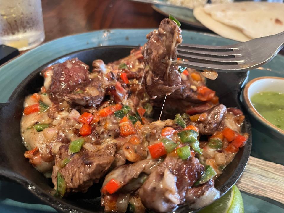 fork digging into alambre de res entrée from la hacienda de san angel in disney world