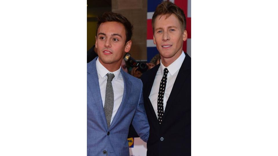 Tom Daley in a blue suit and Dustin Lance Black in a black suit