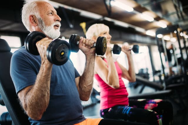 Fit senior sporty couple working out together at gym