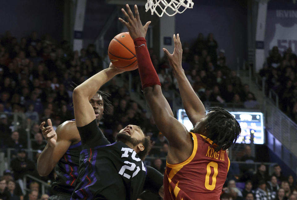 TCU's JaKobe Coles (21) tries to shoot as Iowa State's Tre King (0) defends in the first half of an NCAA basketball game Saturday, Jan. 20, 2024, in Fort Worth, Texas. (AP Photo/Richard W. Rodriguez)