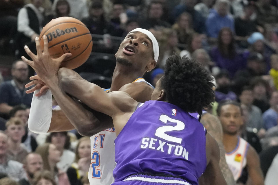 Utah Jazz guard Collin Sexton (2) fouls Oklahoma City Thunder guard Shai Gilgeous-Alexander (2) during the first half of an NBA basketball game Thursday, Jan. 18, 2024, in Salt Lake City. (AP Photo/Rick Bowmer)