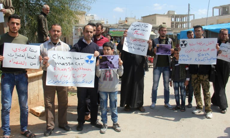 Residents of Khan Sheikhun in northern Syria hold placards and pictures on April 7, 2017 during a protest condemning a suspected chemical weapons attack on their town earlier this week that killed at least 87 people