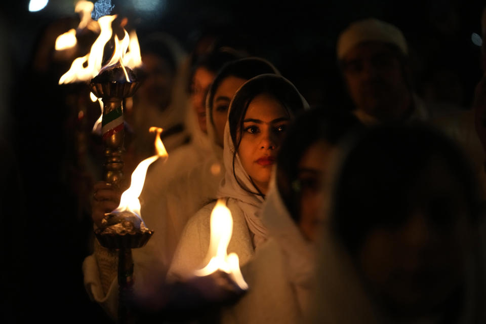 Iranian Zoroastrian youth carry torches to set fire to a prepared pile of wood in a ceremony celebrating their ancient mid-winter Sadeh festival in outskirts of Tehran, Iran, Tuesday, Jan. 30, 2024. Hundreds of Zoroastrian minorities gathered after sunset to mark their ancient feast, creation of fire, dating back to Iran's pre-Islamic past. (AP Photo/Vahid Salemi)