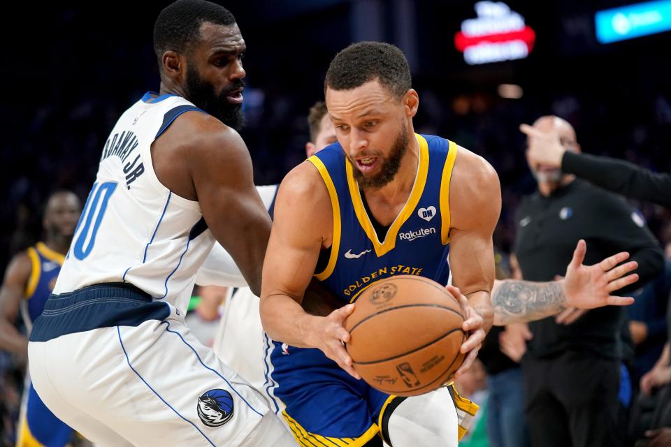 Golden State Warriors guard Stephen Curry (30) holds onto the ball next to Dallas Mavericks forward Tim Hardaway Jr. (10) in the fourth quarter at the Chase Center.