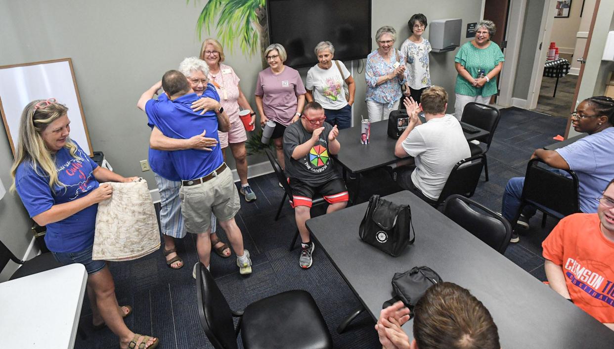 Brad Hammond, right, a member of the Rainbow Gang Special Population day care, hugs Anne Medlin a volunteer for Quilts of Valor Foundation, after Kim Price and the group presented a special quilt in Anderson, S.C., Monday, August 12, 2024. The Rainbow Gang group made colorful squares as an art project, which Price secretly made into a quilt which she surprised them with Monday.