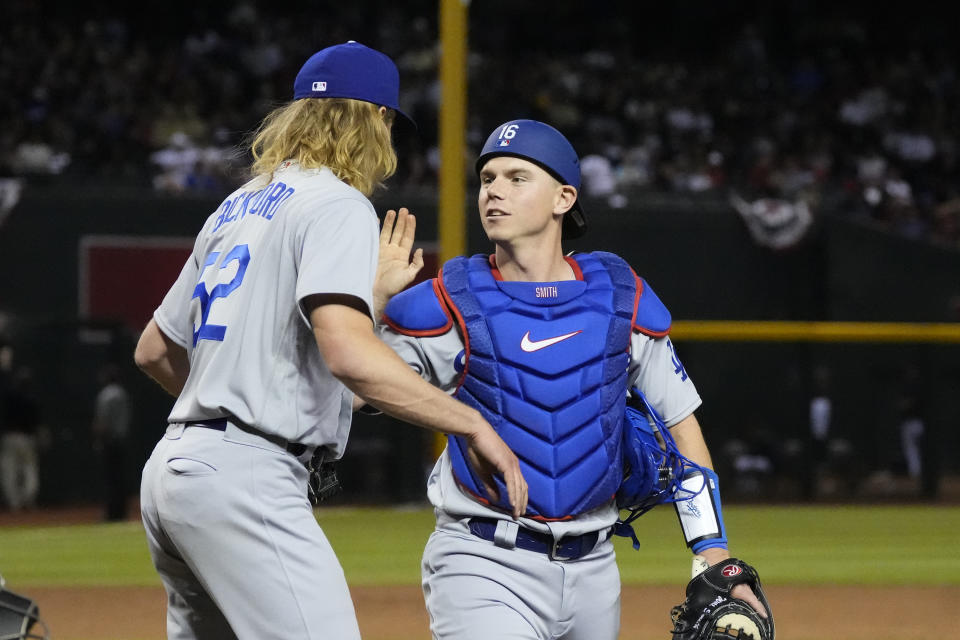 Los Angeles Dodgers catcher Will Smith (16) slaps relief pitcher Phil Bickford on the chest after Smith made a catch on a popup hit by Arizona Diamondbacks' Corbin Carroll during the eighth inning of a baseball game Thursday, April 6, 2023, in Phoenix. The Dodgers won 5-2. (AP Photo/Ross D. Franklin)