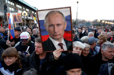 A supporter of Russian President Vladimir Putin holds his portrait in Belgrade, Serbia, January 17, 2019. REUTERS/Kacper Pempel