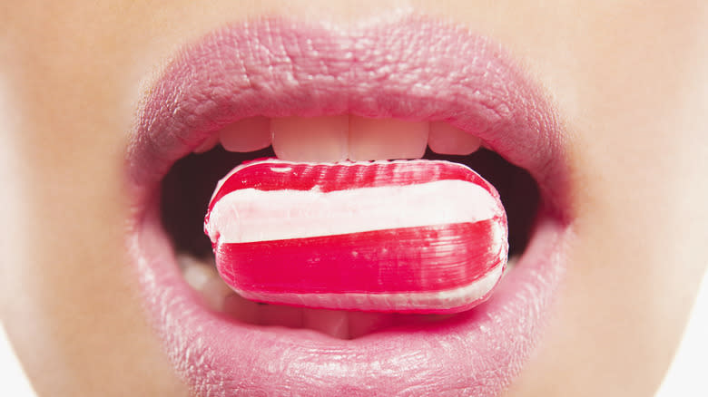 mouth holding peppermint candy
