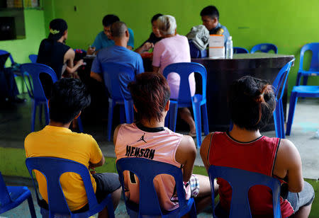 Residents sit and wait for their turn during a drug testing operation run by police in Payatas, Quezon City, Metro Manila, Philippines August 23, 2017. REUTERS/Dondi Tawatao