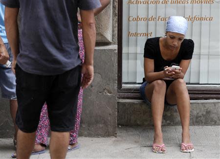 A woman uses her mobile phone on a street in Havana Arpil 6, 2014. REUTERS/Enrique De La Osa