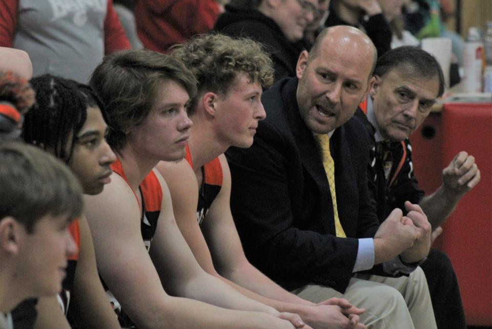 Cheboygan head coach Jason Friday talks to senior Connor Gibbons on the bench during the second half of Friday night's clash at Onaway.