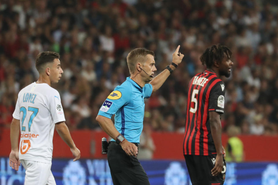 TOPSHOT - French referee Clement Turpin (C) gestures as he haltes the game after supporters shouted homophobic songs and brandished banners during the French L1 football match between OGC Nice and Olympique de Marseille (OM) on August 28, 2019 at the "Allianz Riviera" stadium in Nice, southeastern France. (Photo by VALERY HACHE / AFP)        (Photo credit should read VALERY HACHE/AFP/Getty Images)