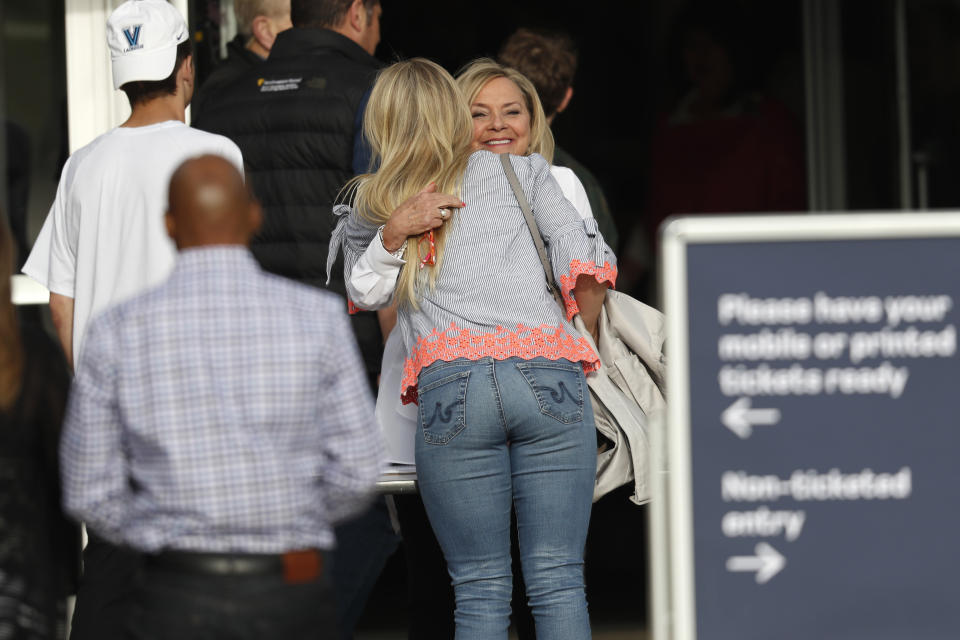 Greeter Beth Woydziak, facing camera, greets a woman arriving to a faith-based memorial service for the victims of the massacre at Columbine High School nearly 20 years earlier at a community church, Thursday, April 18, 2019, in Littleton, Colo. (AP Photo/David Zalubowski)