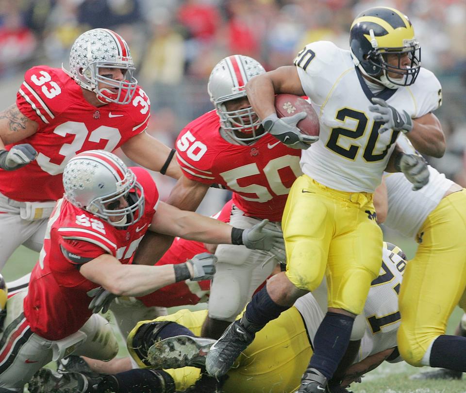 Ohio State's Vernon Gholston, 50, James Laurinaitis, 33, and John Kerr, 52, corral Michigan's Mike Hart, 20, keeping him from a fourth down conversion in the first half of their game at the Ohio Stadium, November 18, 2006.