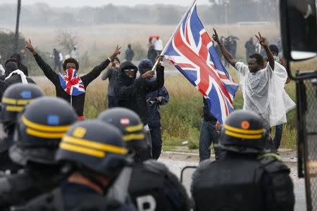 Migrants face off with French riot police during a protest near the area called the "jungle" where they live in Calais, France, October 1, 2016. REUTERS/Pascal Rossignol