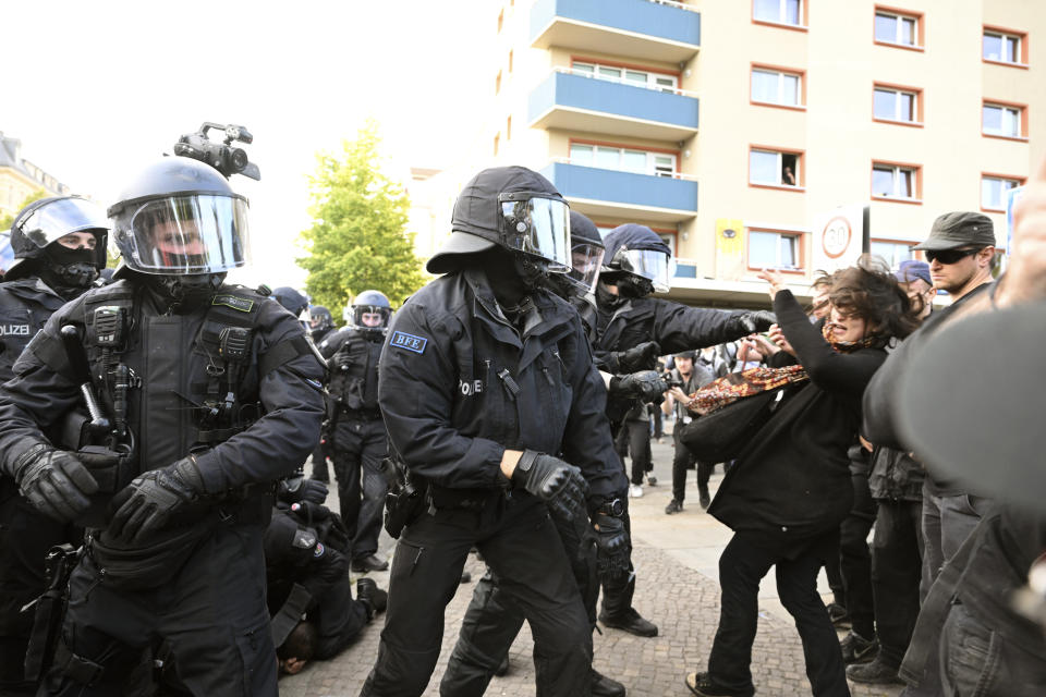 Police officers react with a woman during a left-wing demonstration, in Leipzig, Germany, Saturday, June 3, 2023. The demonstration is against the verdict in the trial of Lina E. The Dresden Higher Regional Court sentenced the student to five years and three months imprisonment. (Robert Michael/dpa via AP)