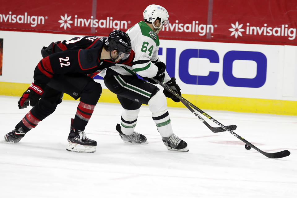 Carolina Hurricanes' Brett Pesce (22) works against Dallas Stars' Tanner Kero (64) during the third period of an NHL hockey game in Raleigh, N.C., Saturday, Jan. 30, 2021. (AP Photo/Karl B DeBlaker)