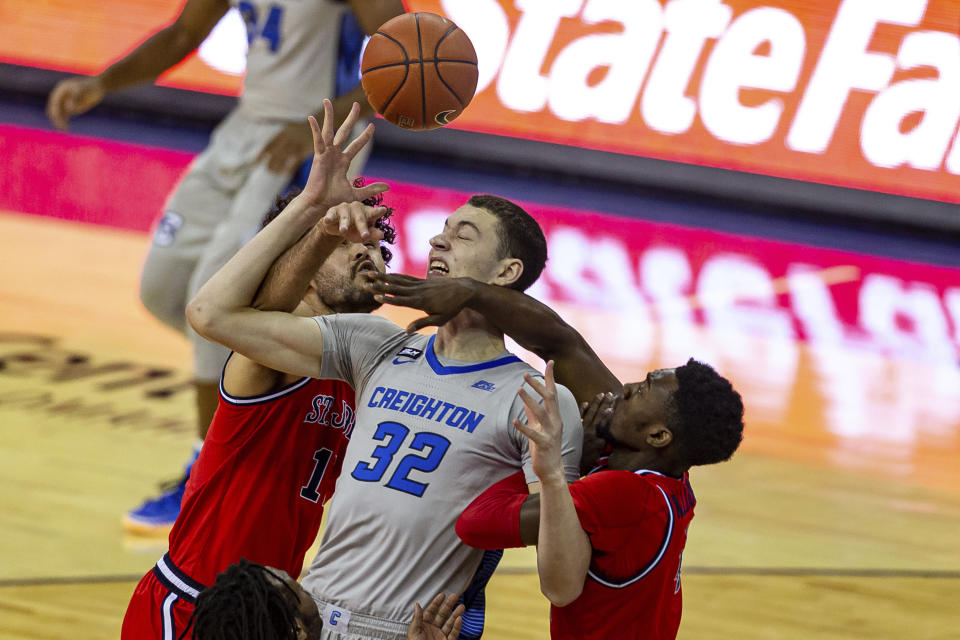 Creighton center Ryan Kalkbrenner (32) fights for a rebound against St. John's forward Josh Roberts (1) and St. John's guard Greg Williams Jr. (4) in the first half of an NCAA college basketball game Saturday, Jan. 9, 2021, in Omaha, Neb. (AP Photo/John Peterson)