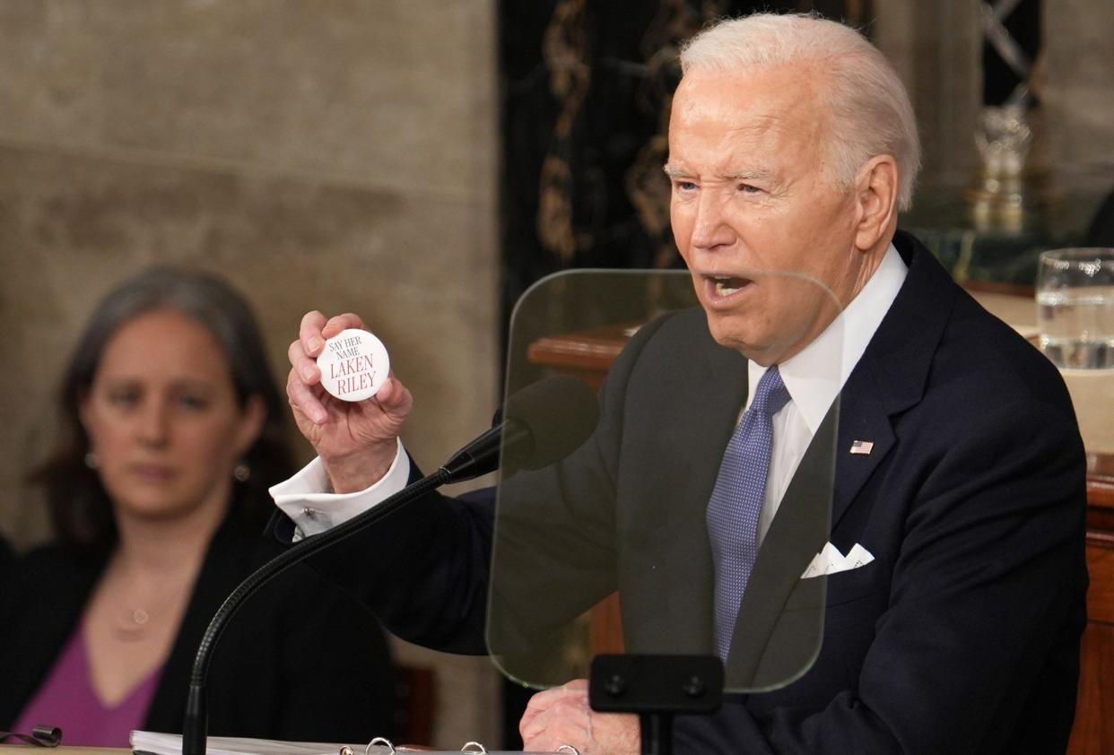 President Joe Biden delivers the State of the Union address to Congress at the U.S. Capitol in Washington. He is holding a button remembering the killing of 22-year-old Laken Riley, a nursing student whose body was found in a wooded area on the University of Georgia's main campus in Athens, Ga.