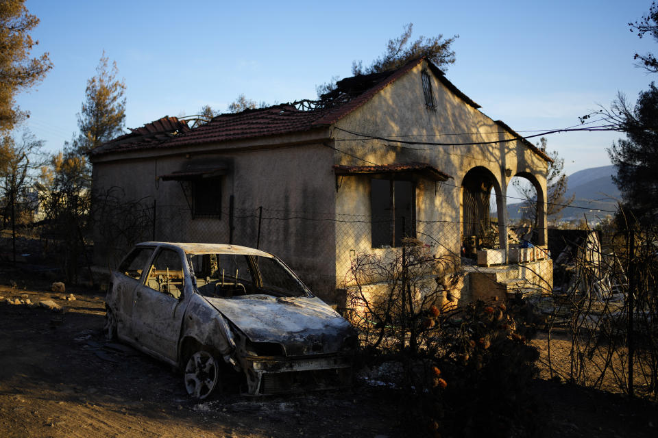 Damaged house and car, which had been burned in a mid-August wildfire, are seen in Halandri suburb in northern Athens, Sunday, Aug. 25, 2024. (AP Photo/Thanassis Stavrakis)