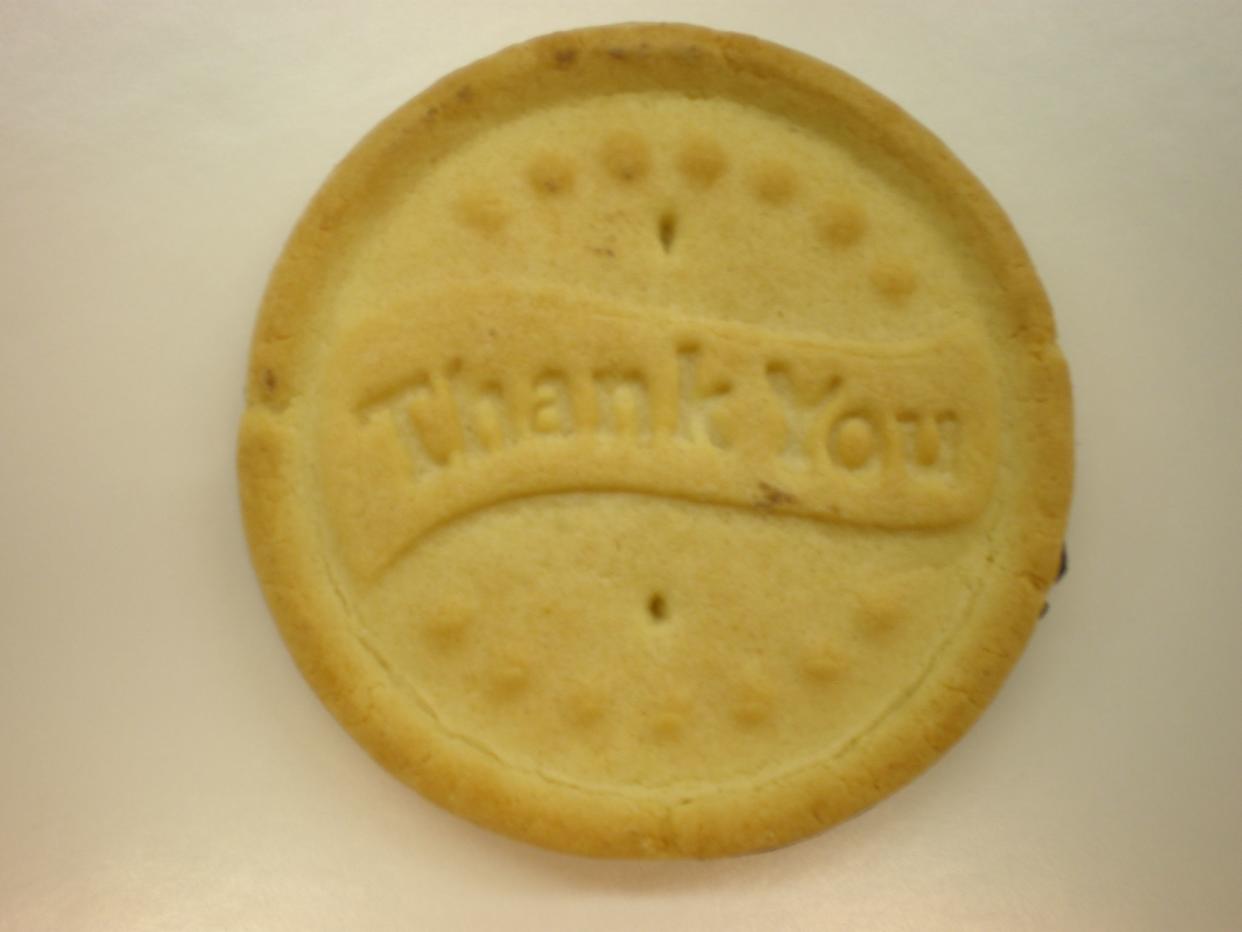 A Girl Scouts of the USA All Abouts cookie with "Thank you" in English