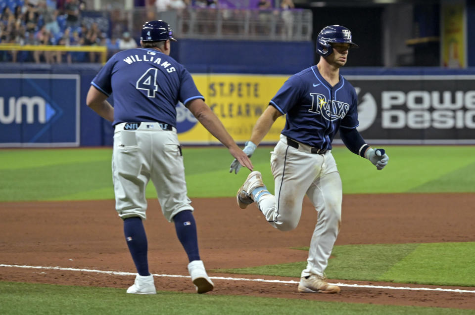 Tampa Bay Rays third base coach Brady Williams (4) congratulates Ben Rortvedt for a two-run home run off Seattle Mariners reliever Mike Baumann during the sixth inning of a baseball game Tuesday, June 25, 2024, in St. Petersburg, Fla. (AP Photo/Steve Nesius)