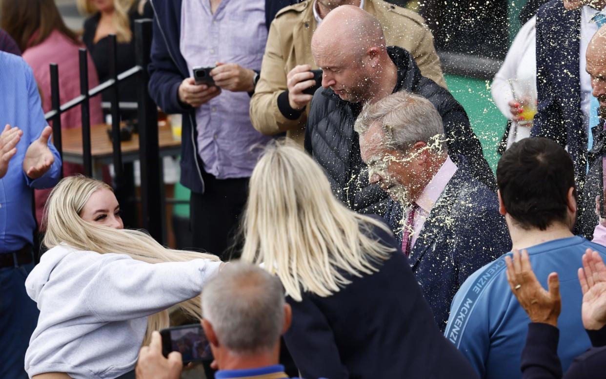 A woman throws a milkshake at Nigel Farage in Clacton-on-sea, Essex