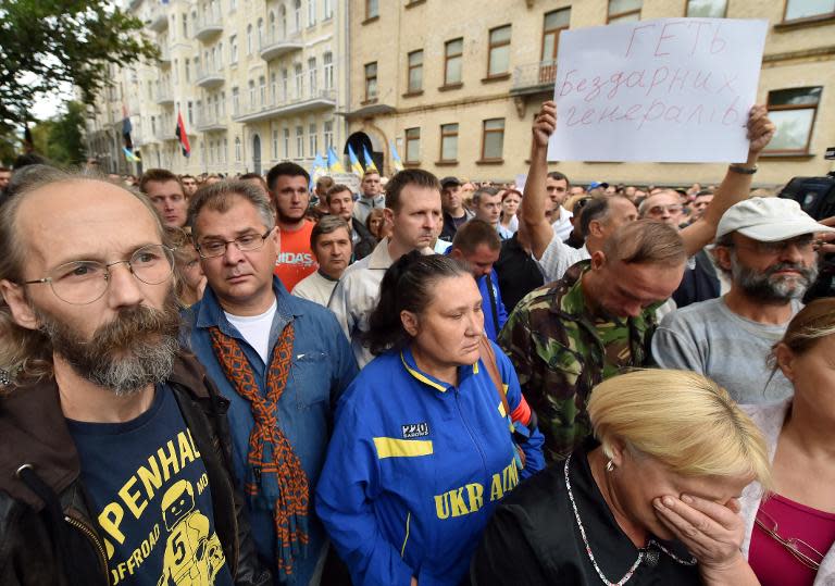 People hold a placard reading "Down with incompetent generals!" during a rally in front of Ukrainian President Petro Poroshenko's office in Kiev on August 27, 2014