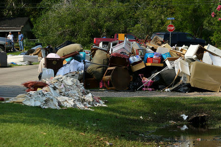 FILE PHOTO: Flood-damaged contents from people's homes line the street following the aftermath of tropical storm Harvey in Wharton, Texas, U.S., September 6, 2017. REUTERS/Mike Blake/File Photo