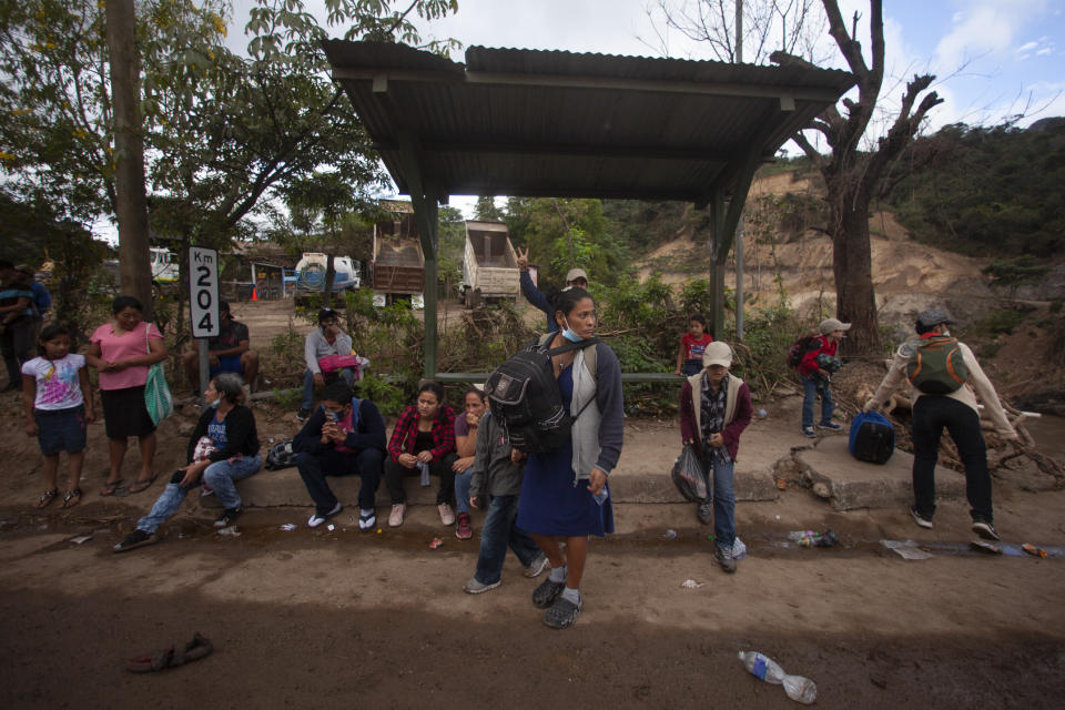 Migrants hoping to reach the distant U.S. border rest on the side of a highway, in Jocotan, Guatemala, Saturday, Jan. 16, 2021. Honduran migrants pushed their way into Guatemala Friday night without registering, a portion of a larger migrant caravan that had left the Honduran city of San Pedro Sula before dawn, Guatemalan authorities said. (AP Photo/Sandra Sebastian)