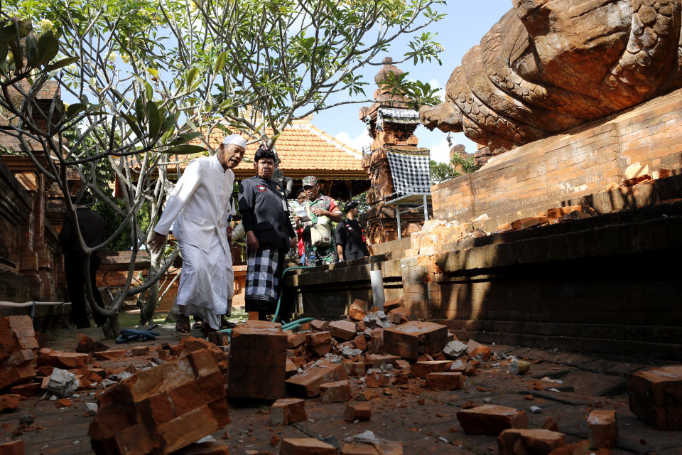 Balinese men check a damaged temple in Bali, Indonesia Tuesday, July 16, 2019. Indonesian authorities say a subsea earthquake shook Bali, Lombok and East Java on Tuesday, causing damage to homes and temples. (AP Photo/Firdia Lisnawati)