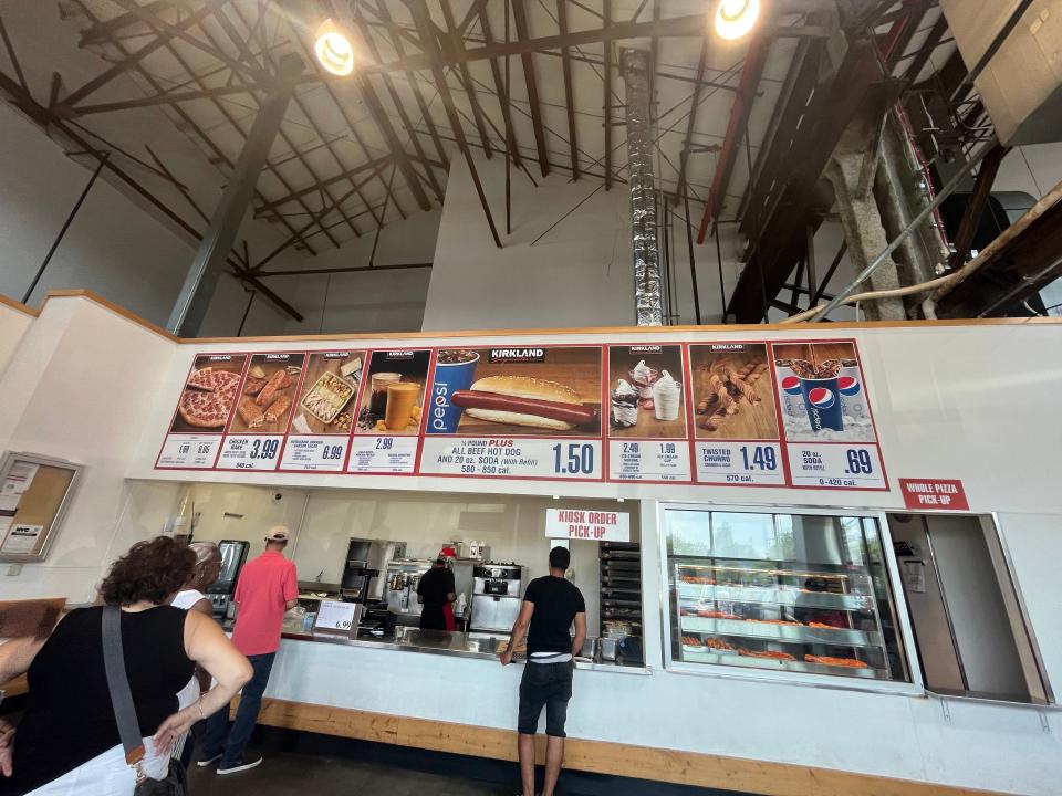 Costco food court with menu and people waiting in line