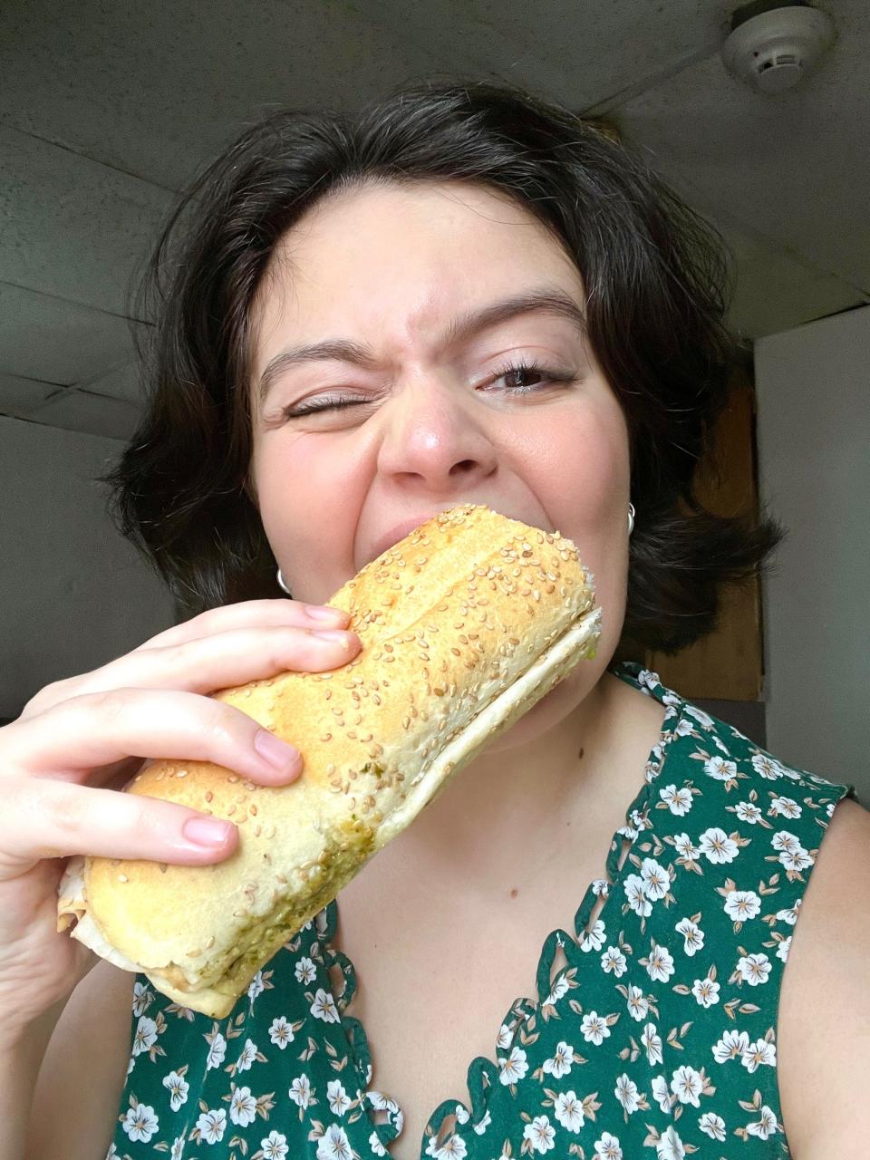 Selfie of Insider's Gabi Stevenson eating a hoagie in a green floral dress.