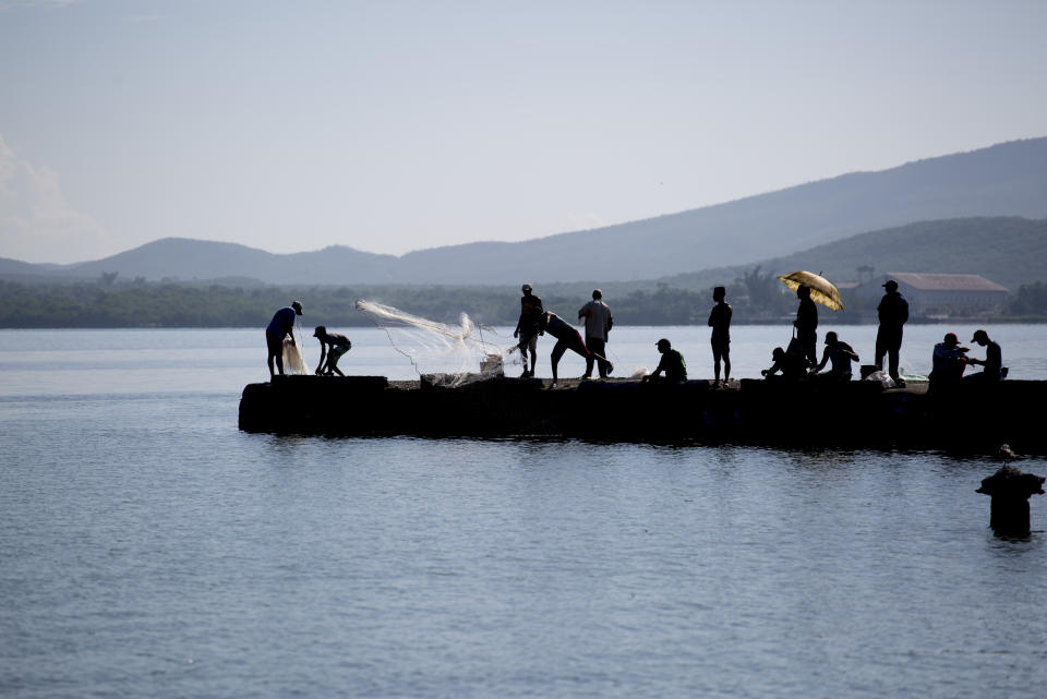 Residents fish in Caimanera, Cuba, Thursday, Nov. 14, 2019. President Miguel Diaz-Canel is making his first trip to the town of Caimanera, the closest point in Cuba to the U.S. naval base at Guantanamo Bay. He arrived on Thursday morning. (AP Photo/Ismael Francisco)