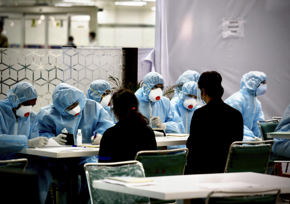 Health workerS screen stranded Indian who arrived from Singapore at the Indira Gandhi international airport in New Delhi, India, Friday, May 8,2020. India is carrying out several repatriation flights to bring back citizens stranded in various countries. (AP Photo/Manish Swarup)