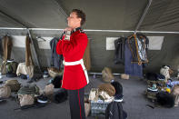 A member of the Coldstream Guards prepares his uniform before rehearsing for Britain's Prince Philip's funeral on the Drill Square at the Army Training Centre Pirbright in Woking, Surrey, England Wednesday April 14, 2021. Prince Philip's funeral will be held at Windsor Castle on Saturday following his death at the age of 99 on April 10. (Victoria Jones/PA via AP)