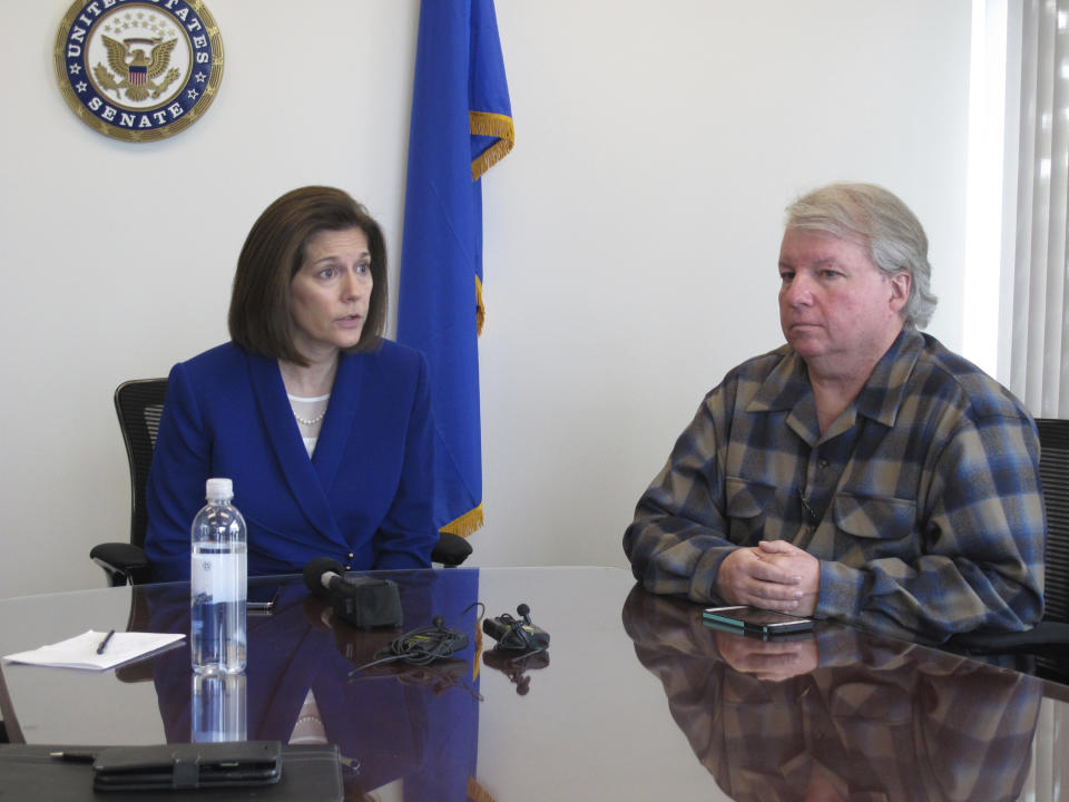 David Pritchett, a furloughed worker for the U.S. Bureau of Land Management, looks on as Sen. Catherine Cortez Masto, D-Nev., talks to reporters Friday, Jan. 11, 2019, in her office in Reno about the impacts of the partial government shutdown. Pritchett, a BLM planner in Reno, says the effects of the shutdown will have a ripple effect on federal land management long after the government fully reopens because of deadlines that were missed for federal permits on a whole range of projects, from gold mines to large recreational events. (AP Photo/Scott Sonner)